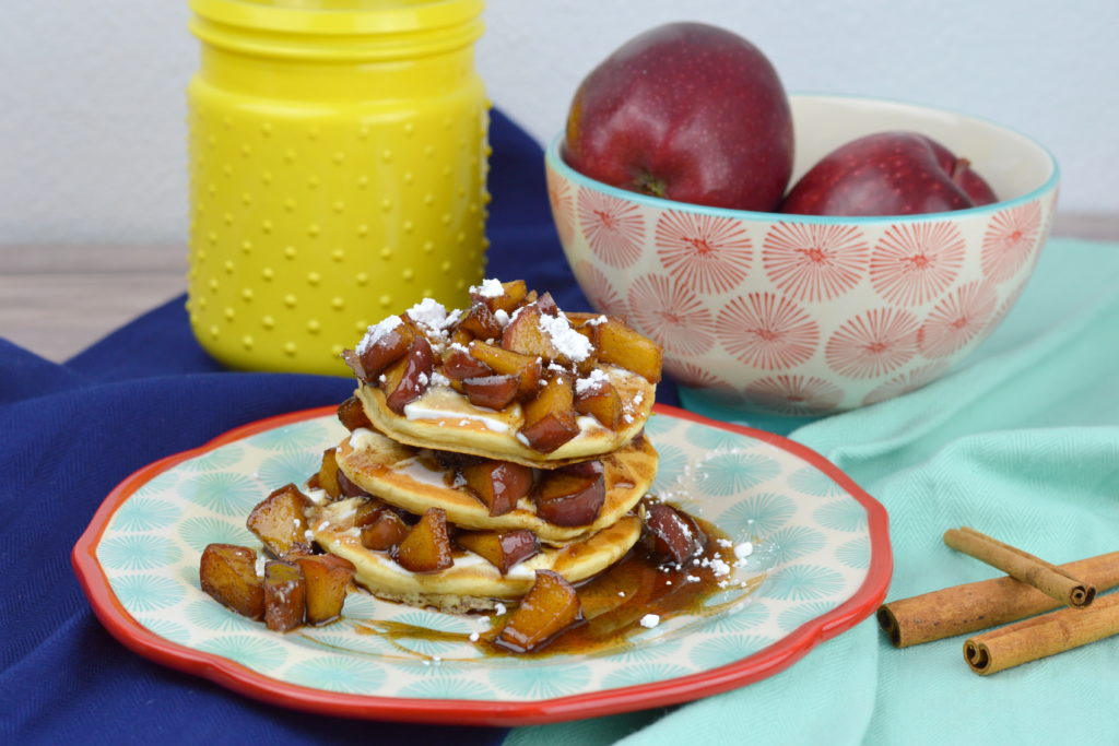 Old fashioned and fluffy pancakes topped with sour cream, fresh apples cooked in a cinnamon syrup glaze and powdered sugar make these Apple Cinnamon Pancakes the best fall recipe for breakfast, brunch, or dinner.