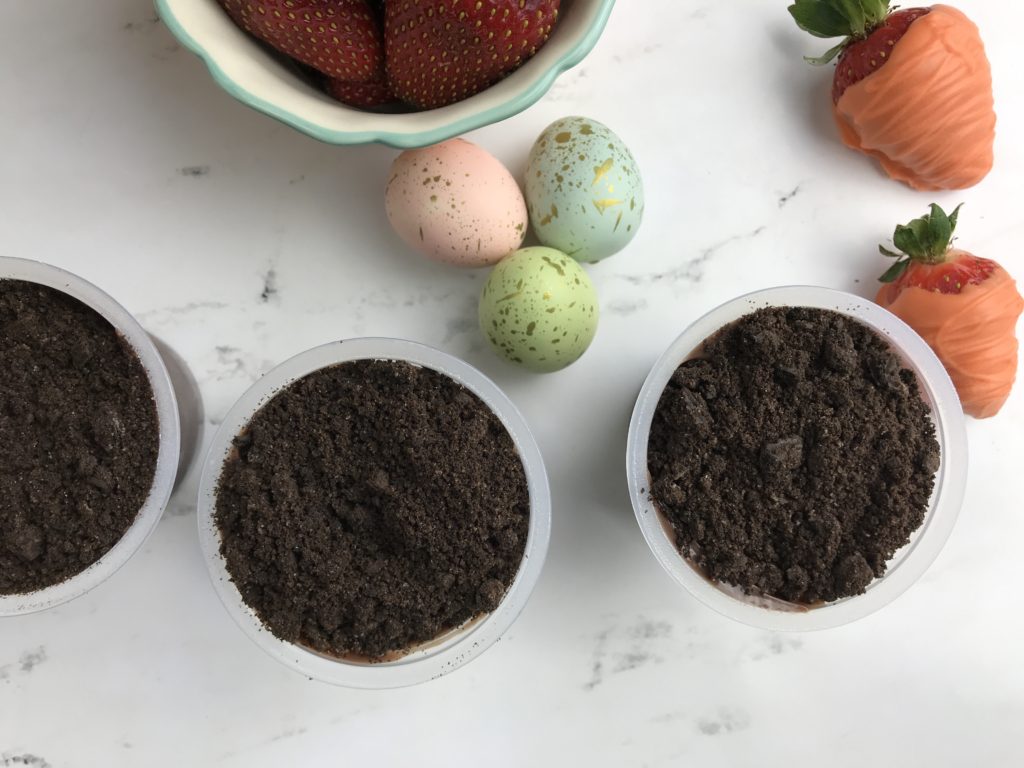 These adorable Carrot Patch Dirt Cups are perfect for spring and easy to make using store bought pudding cups, topped with crumbled chocolate sandwich cookies, and chocolate-covered strawberry “carrots”.  