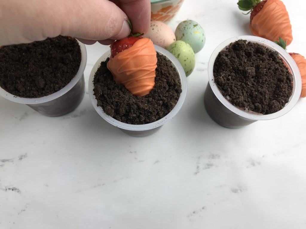 These adorable Carrot Patch Dirt Cups are perfect for spring and easy to make using store bought pudding cups, topped with crumbled chocolate sandwich cookies, and chocolate-covered strawberry “carrots”.  