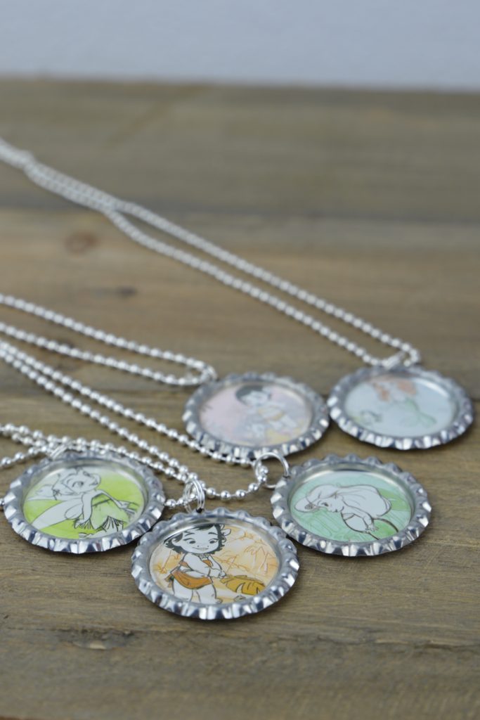 These fun and easy bottle cap necklaces are a great DIY craft for fish extender or pixie dust gifts for your next Disney Cruise.