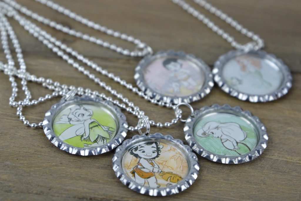 These fun and easy bottle cap necklaces are a great DIY craft for fish extender or pixie dust gifts for your next Disney Cruise.