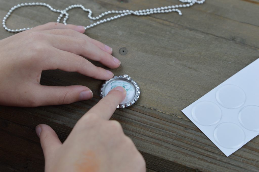 These fun and easy bottle cap necklaces are a great DIY craft for fish extender or pixie dust gifts for your next Disney Cruise.