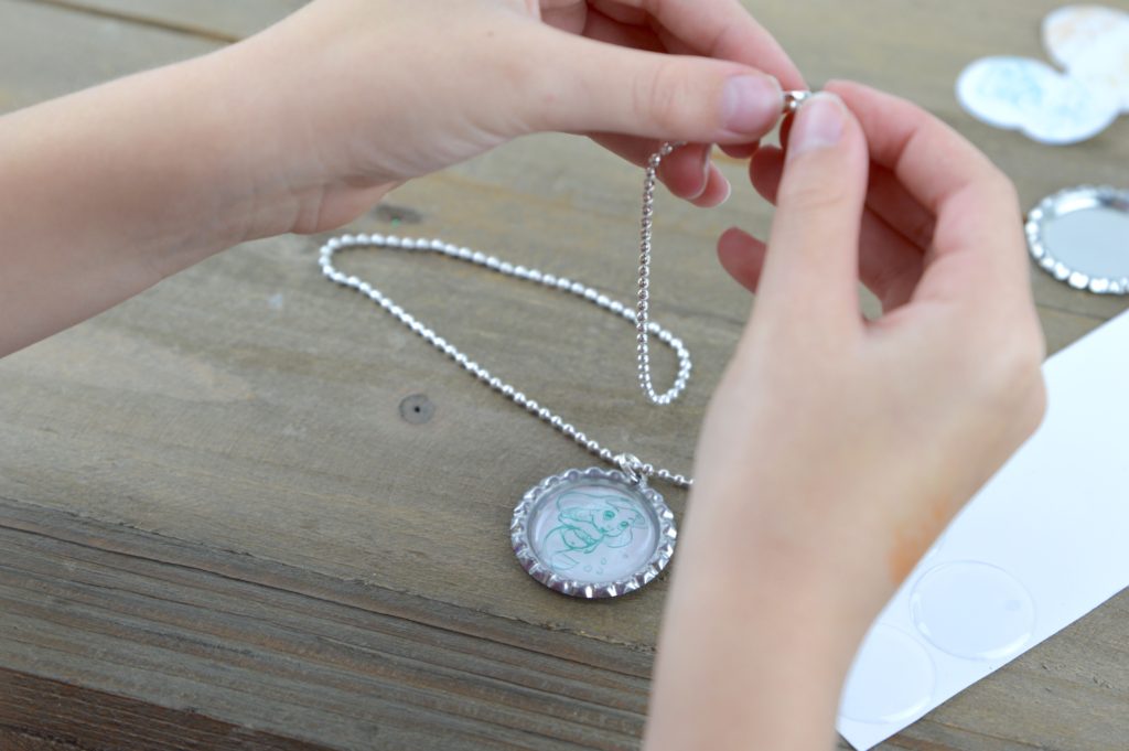 These fun and easy bottle cap necklaces are a great DIY craft for fish extender or pixie dust gifts for your next Disney Cruise.