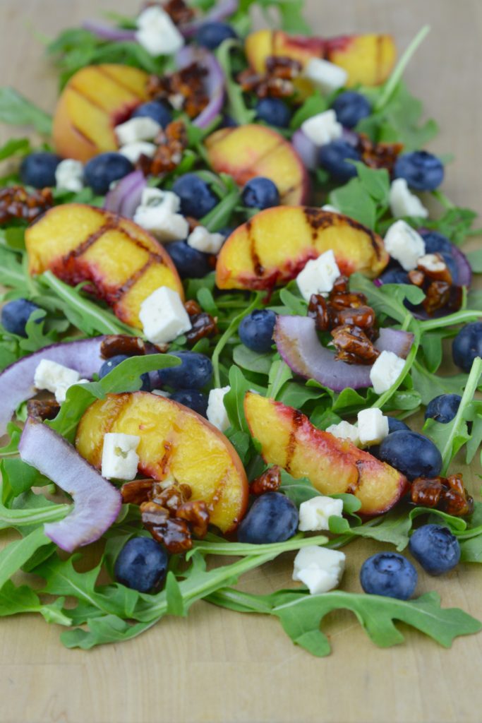 Grilled Peach Salad is the best summer side dish recipe!  The peaches and onions are grilled and served with arugula, blueberries, candied pecans, and blue cheese. 