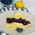 Delicious French-inspired Blueberry Cream Cheese Crepes filled with sweet cream cheese and topped with bursting blueberries.