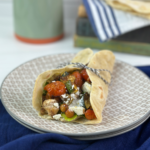 These Mediterranean Wraps feature a pita/tortilla stuffed with roasted vegetables, chickpeas, seasoned chicken, hummus, and a feta sauce.
